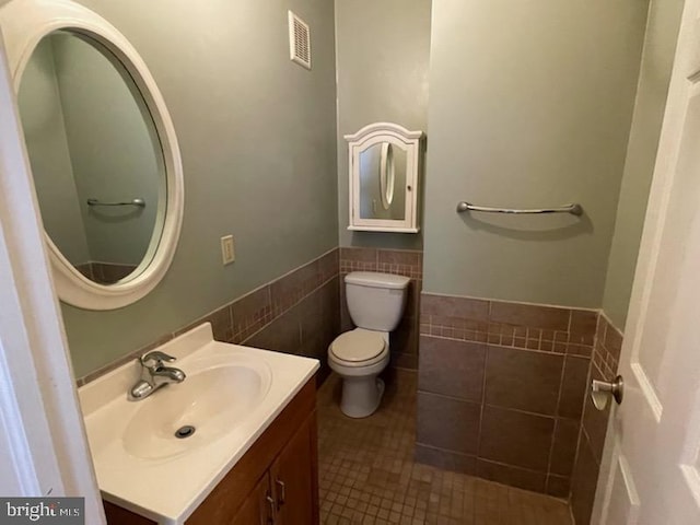 102 N 11th St, Reading, PA 19601 - bathroom with toilet, vanity, tile walls, wainscoting, and tile patterned flooring