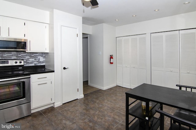 507 Essex Ct, Mantua, NJ 08051 - kitchen with stainless steel appliances, dark countertops, ceiling fan, backsplash, and white cabinetry
