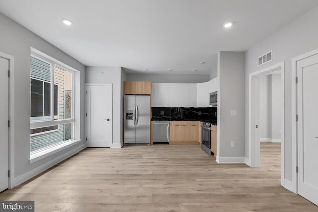 2937 Page St, Philadelphia, PA 19121 - kitchen featuring appliances with stainless steel finishes, backsplash, dark countertops, light wood-style floors, and baseboards