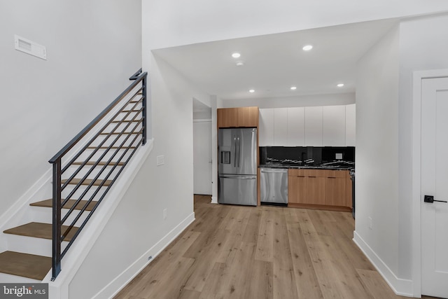2937 Page St, Philadelphia, PA 19121 - kitchen featuring appliances with stainless steel finishes, dark countertops, light wood-style floors, modern cabinets, and backsplash