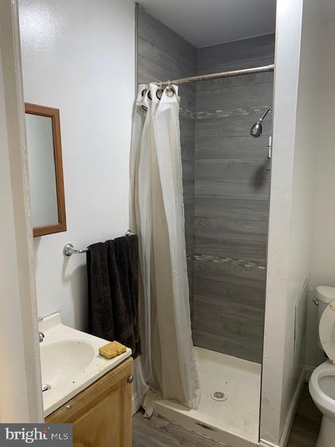 812 Tulip St, Camden, NJ 08104 - bathroom featuring toilet, vanity, a stall shower, and wood finished floors