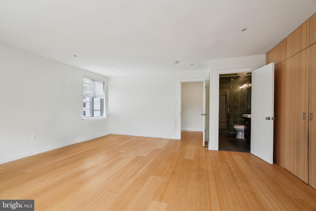 2213 Race St Unit 202, Philadelphia, PA 19103 - unfurnished bedroom featuring light wood-style flooring, baseboards, and connected bathroom