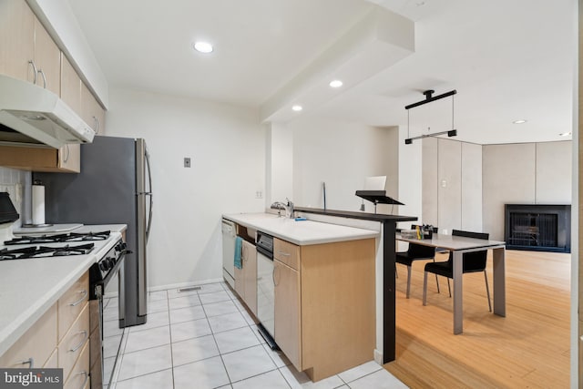 2213 Race St Unit 202, Philadelphia, PA 19103 - kitchen with under cabinet range hood, black range with gas stovetop, a peninsula, recessed lighting, and light countertops