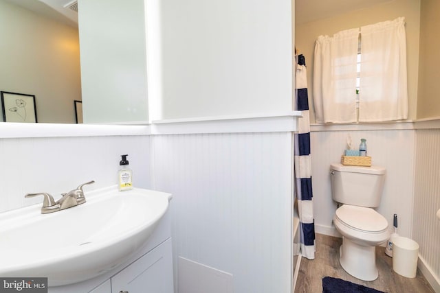 167 Windmill Rd, Willow Grove, PA 19090 - full bath featuring vanity, toilet, wood finished floors, a shower with curtain, and a wainscoted wall