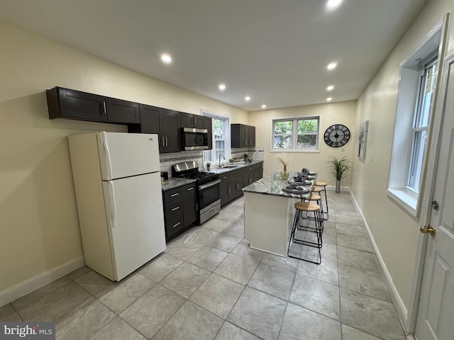 2411 N W St, Wilmington, DE 19802 - kitchen featuring appliances with stainless steel finishes, recessed lighting, a kitchen island, baseboards, and decorative backsplash