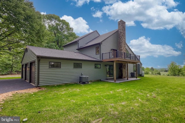 2655 Gap Newport Pike, West Grove, PA 19390 - back of property featuring central air condition unit, a lawn, a balcony, a chimney, and a garage