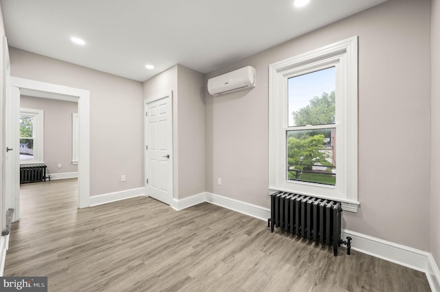 552 Willow St, Pottstown, PA 19464 - unfurnished room featuring radiator heating unit, an AC wall unit, light wood-type flooring, baseboards, and recessed lighting