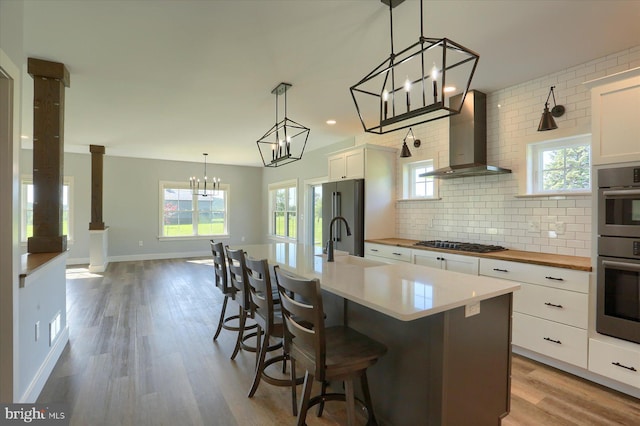 104 Lightfoot Ln, Dillsburg, PA 17019 - kitchen featuring wall chimney range hood, appliances with stainless steel finishes, wood counters, a sink, and decorative backsplash
