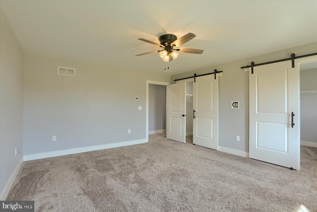 104 Lightfoot Ln, Dillsburg, PA 17019 - unfurnished bedroom featuring a barn door, a spacious closet, carpet floors, and baseboards