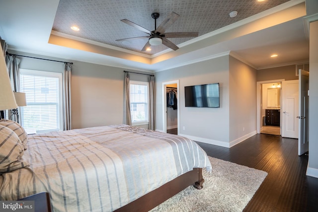 22270 Foggy Ridge Ter, Ashburn, VA 20148 - bedroom featuring ornamental molding, baseboards, multiple windows, a tray ceiling, and dark wood-style flooring