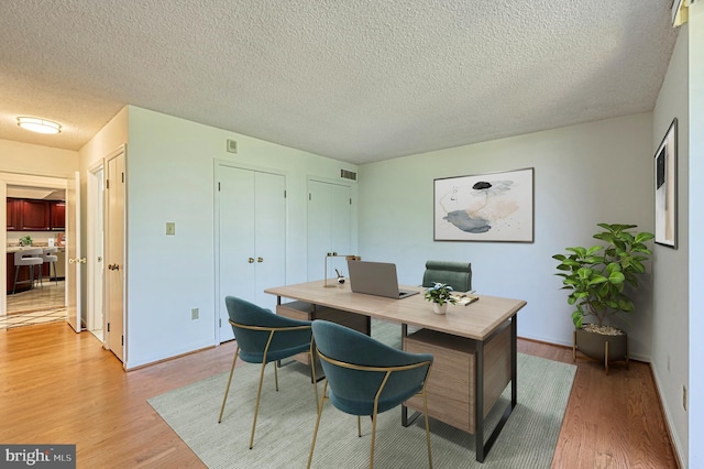 1101 S Arlington Ridge Rd Unit 216, Arlington, VA 22202 - home office featuring light wood-type flooring, a textured ceiling, and baseboards