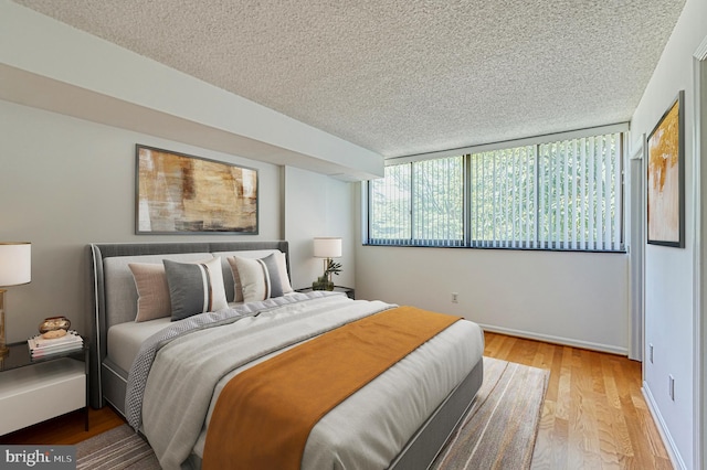 1101 S Arlington Ridge Rd Unit 216, Arlington, VA 22202 - bedroom featuring a textured ceiling, light wood-style flooring, and baseboards