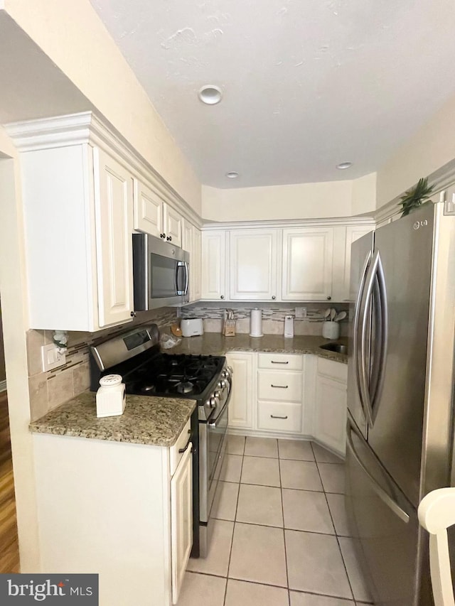 1820 S Dover St, Philadelphia, PA 19145 - kitchen with appliances with stainless steel finishes, decorative backsplash, and white cabinets