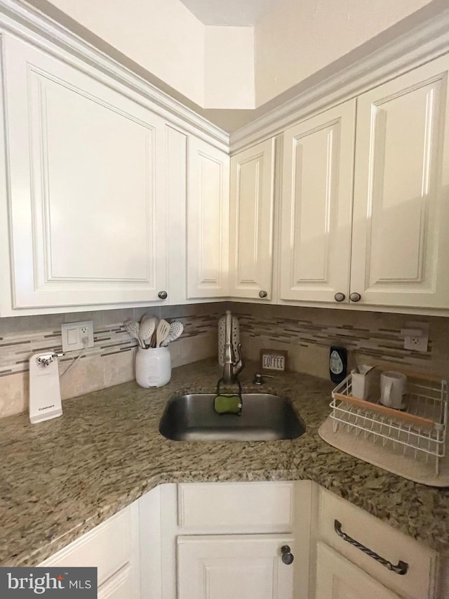 1820 S Dover St, Philadelphia, PA 19145 - kitchen featuring white cabinetry, decorative backsplash, a sink, and light stone counters