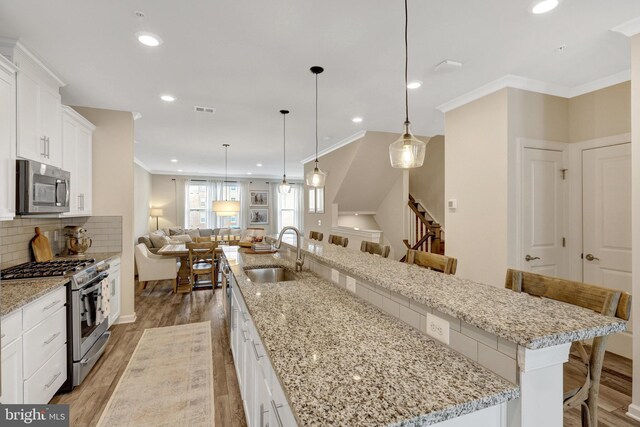 45210 Lettermore Sq, Sterling, VA 20166 - kitchen featuring appliances with stainless steel finishes, a sink, a large island with sink, light wood-style flooring, and open floor plan