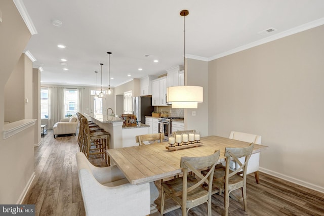 45210 Lettermore Sq, Sterling, VA 20166 - dining area featuring crown molding, baseboards, wood finished floors, and recessed lighting