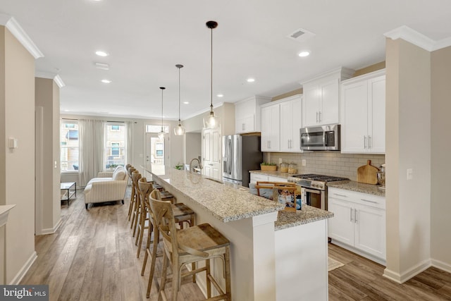 45210 Lettermore Sq, Sterling, VA 20166 - kitchen featuring stainless steel appliances, crown molding, backsplash, baseboards, and light wood-style flooring