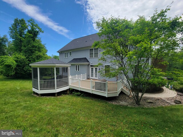 21785 Watson Rd, Leesburg, VA 20175 - back of house featuring a lawn, a shingled roof, a deck, and a sunroom