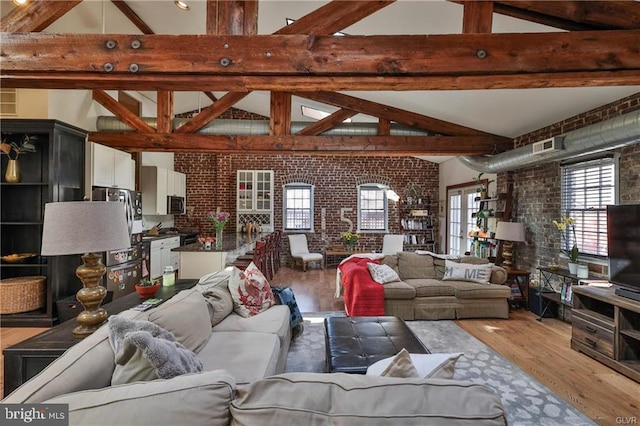 517 W Burke St, Easton, PA 18042 - living area with brick wall, wood finished floors, plenty of natural light, beam ceiling, and high vaulted ceiling