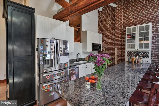 517 W Burke St, Easton, PA 18042 - kitchen with appliances with stainless steel finishes, a sink, brick wall, a peninsula, and a kitchen breakfast bar