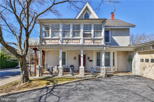 517 W Burke St, Easton, PA 18042 - view of front of home with a porch, brick siding, asphalt driveway, a garage, and a balcony