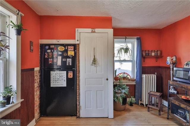 517 W Burke St, Easton, PA 18042 - foyer with radiator, wainscoting, hardwood / wood-style flooring, a textured ceiling, and wooden walls