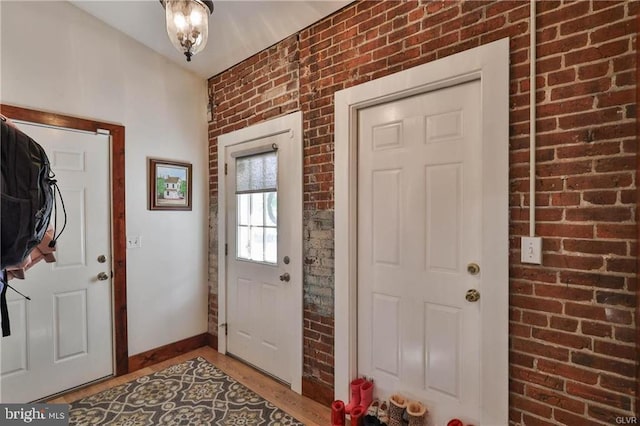517 W Burke St, Easton, PA 18042 - foyer featuring brick wall, light wood-style flooring, and baseboards