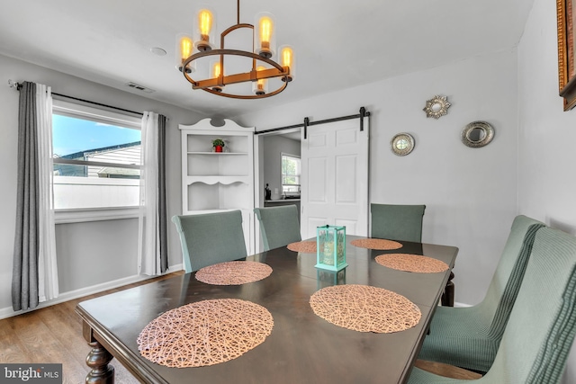 113 Tremont St, Manassas Park, VA 20111 - dining area with a chandelier, a barn door, wood finished floors, and baseboards