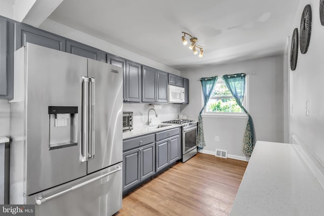 113 Tremont St, Manassas Park, VA 20111 - kitchen with appliances with stainless steel finishes, a sink, gray cabinetry, light countertops, and baseboards