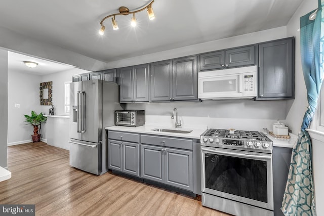 113 Tremont St, Manassas Park, VA 20111 - kitchen with appliances with stainless steel finishes, gray cabinets, a sink, light countertops, and light wood finished floors