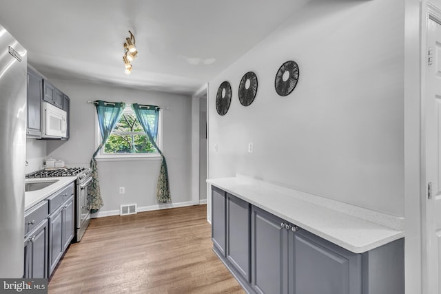 113 Tremont St, Manassas Park, VA 20111 - kitchen with stainless steel appliances, gray cabinets, light wood-style flooring, and light countertops