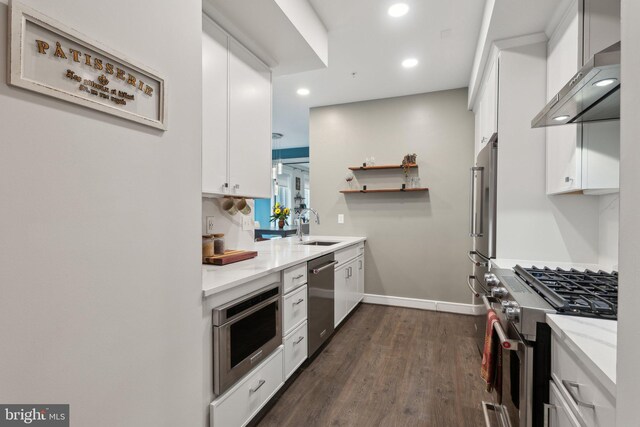 625 Slaters Ln Unit 201, Alexandria, VA 22314 - kitchen featuring stainless steel appliances, wall chimney exhaust hood, white cabinetry, dark wood finished floors, and recessed lighting