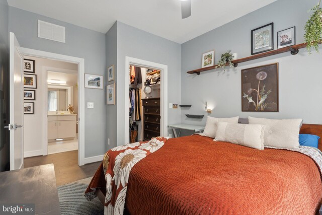 625 Slaters Ln Unit 201, Alexandria, VA 22314 - bedroom with a walk in closet, wood finished floors, a closet, baseboards, and ceiling fan