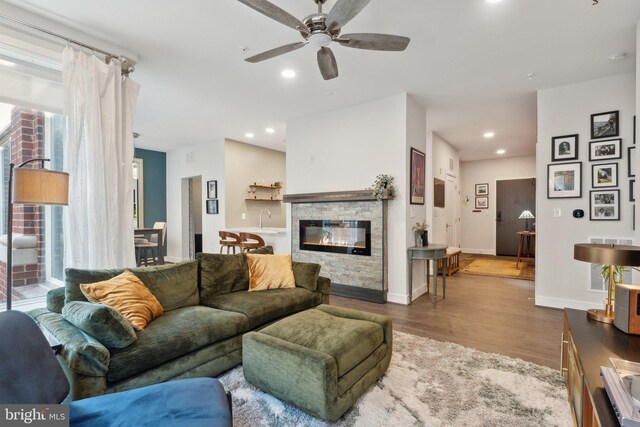 625 Slaters Ln Unit 201, Alexandria, VA 22314 - living room featuring a ceiling fan, wood finished floors, recessed lighting, a stone fireplace, and baseboards