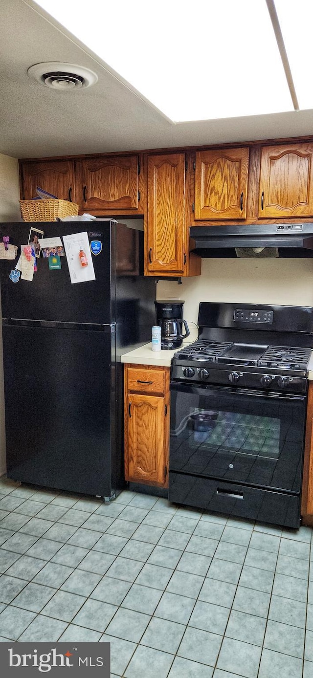 20 Norwick Dr, Forked River, NJ 08731 - kitchen with black appliances, under cabinet range hood, light countertops, and light tile patterned floors