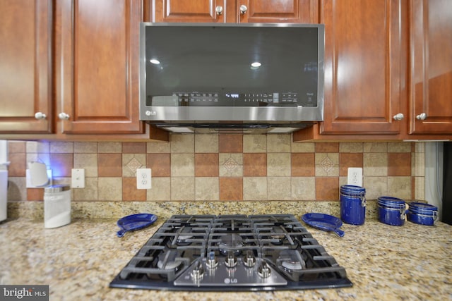 14201 Village Manor Ct, Upper Marlboro, MD 20774 - kitchen with stainless steel microwave, gas cooktop, backsplash, and light stone countertops