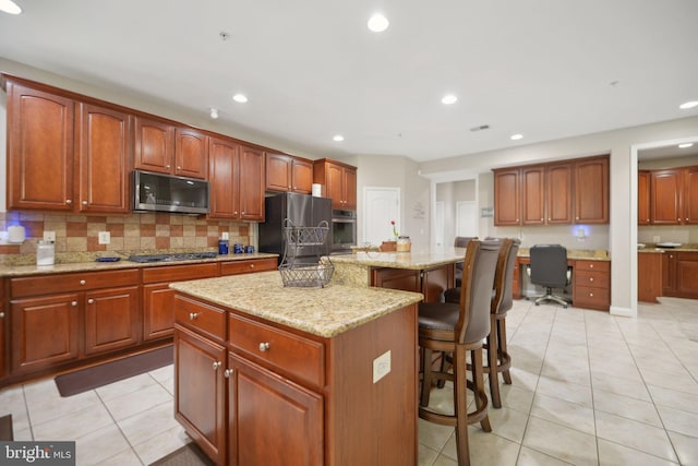 14201 Village Manor Ct, Upper Marlboro, MD 20774 - kitchen with appliances with stainless steel finishes, a kitchen bar, tasteful backsplash, light tile patterned floors, and recessed lighting