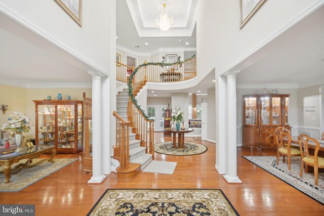 14201 Village Manor Ct, Upper Marlboro, MD 20774 - entrance foyer with decorative columns, stairs, crown molding, a high ceiling, and wood finished floors