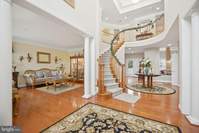 14201 Village Manor Ct, Upper Marlboro, MD 20774 - entrance foyer featuring decorative columns, ornamental molding, wood finished floors, stairway, and a high ceiling