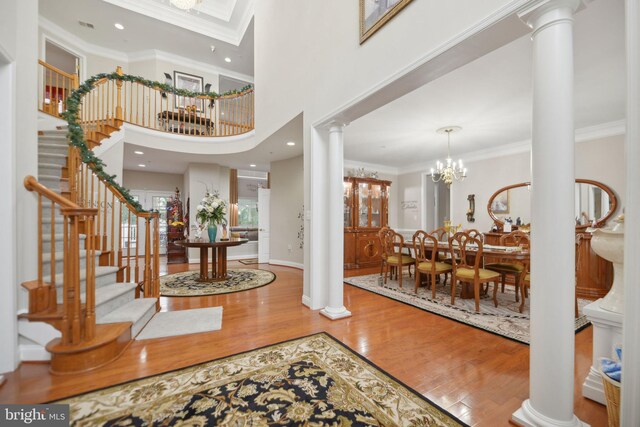 14201 Village Manor Ct, Upper Marlboro, MD 20774 - foyer featuring ornate columns, wood finished floors, stairway, ornamental molding, and a towering ceiling
