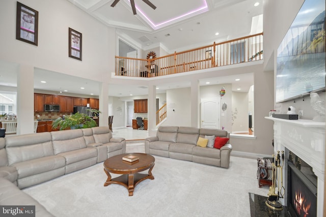 14201 Village Manor Ct, Upper Marlboro, MD 20774 - carpeted living room with a fireplace, a ceiling fan, baseboards, a towering ceiling, and recessed lighting