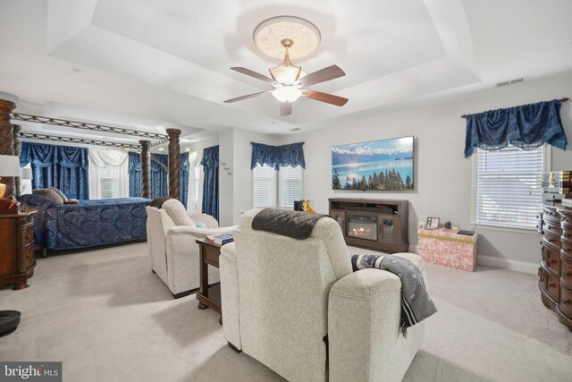 14201 Village Manor Ct, Upper Marlboro, MD 20774 - carpeted living room with a tray ceiling, a ceiling fan, baseboards, and a glass covered fireplace