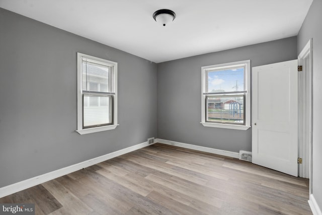 218 Center Ave, Mount Ephraim, NJ 08059 - unfurnished bedroom with multiple windows, wood finished floors, and baseboards
