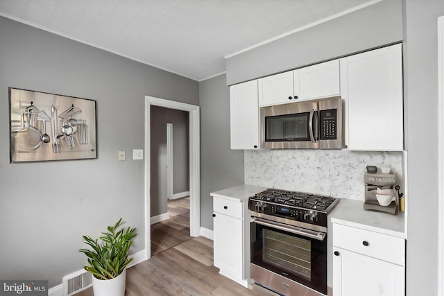 218 Center Ave, Mount Ephraim, NJ 08059 - kitchen featuring appliances with stainless steel finishes, backsplash, crown molding, white cabinets, and light wood-style floors