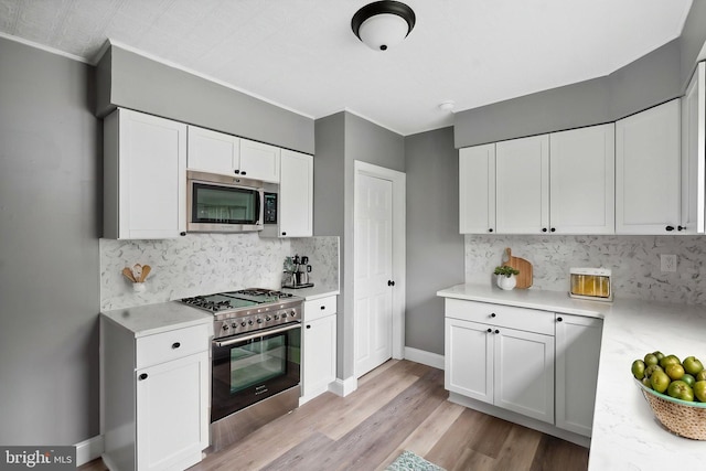 218 Center Ave, Mount Ephraim, NJ 08059 - kitchen with appliances with stainless steel finishes, light countertops, white cabinetry, backsplash, and crown molding