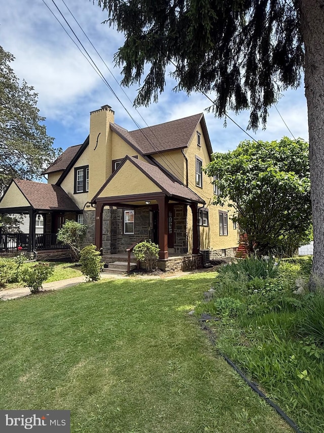 114 Marshall Rd, Lansdowne, PA 19050 - view of front facade with stucco siding, covered porch, a front yard, and stone siding