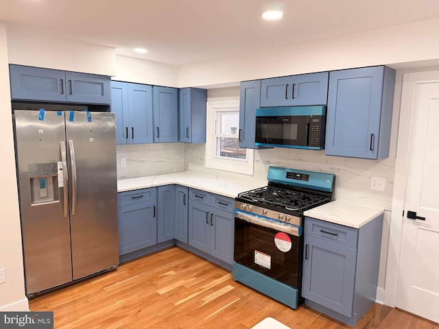 114 Marshall Rd, Lansdowne, PA 19050 - kitchen featuring appliances with stainless steel finishes, decorative backsplash, light wood-style flooring, light stone counters, and recessed lighting