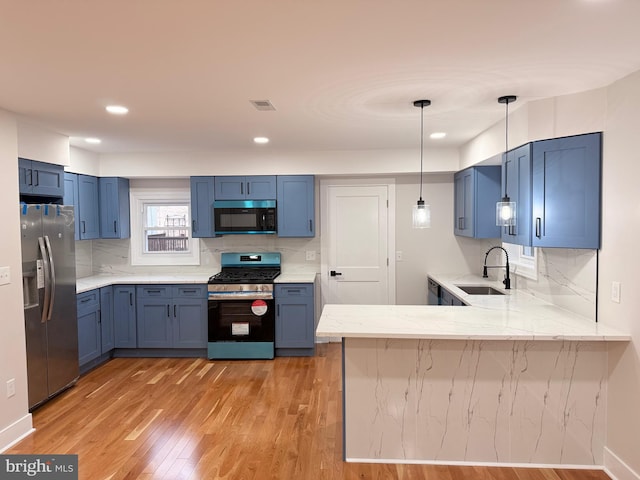 114 Marshall Rd, Lansdowne, PA 19050 - kitchen featuring appliances with stainless steel finishes, a sink, a peninsula, light wood-style floors, and backsplash