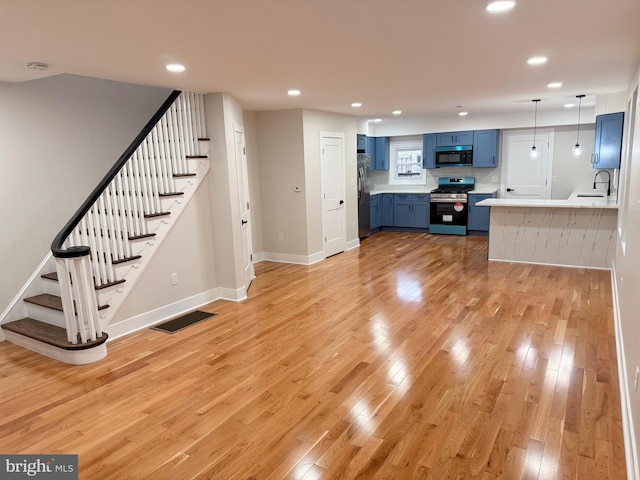 114 Marshall Rd, Lansdowne, PA 19050 - unfurnished living room featuring a sink, light wood-type flooring, recessed lighting, stairs, and baseboards