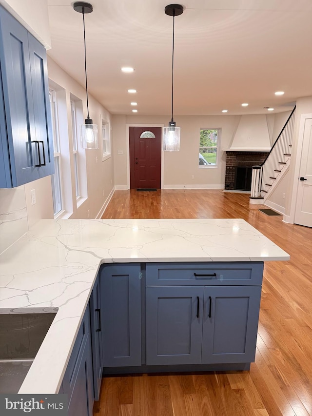 114 Marshall Rd, Lansdowne, PA 19050 - kitchen featuring a peninsula, light wood-type flooring, open floor plan, recessed lighting, and a brick fireplace